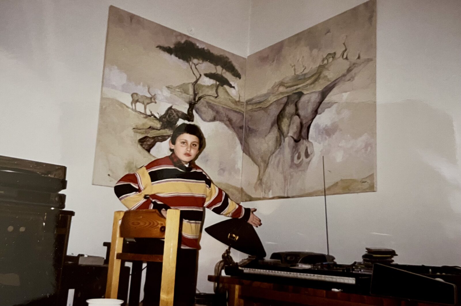 A young Thanos standing beside the family record player and stereo system