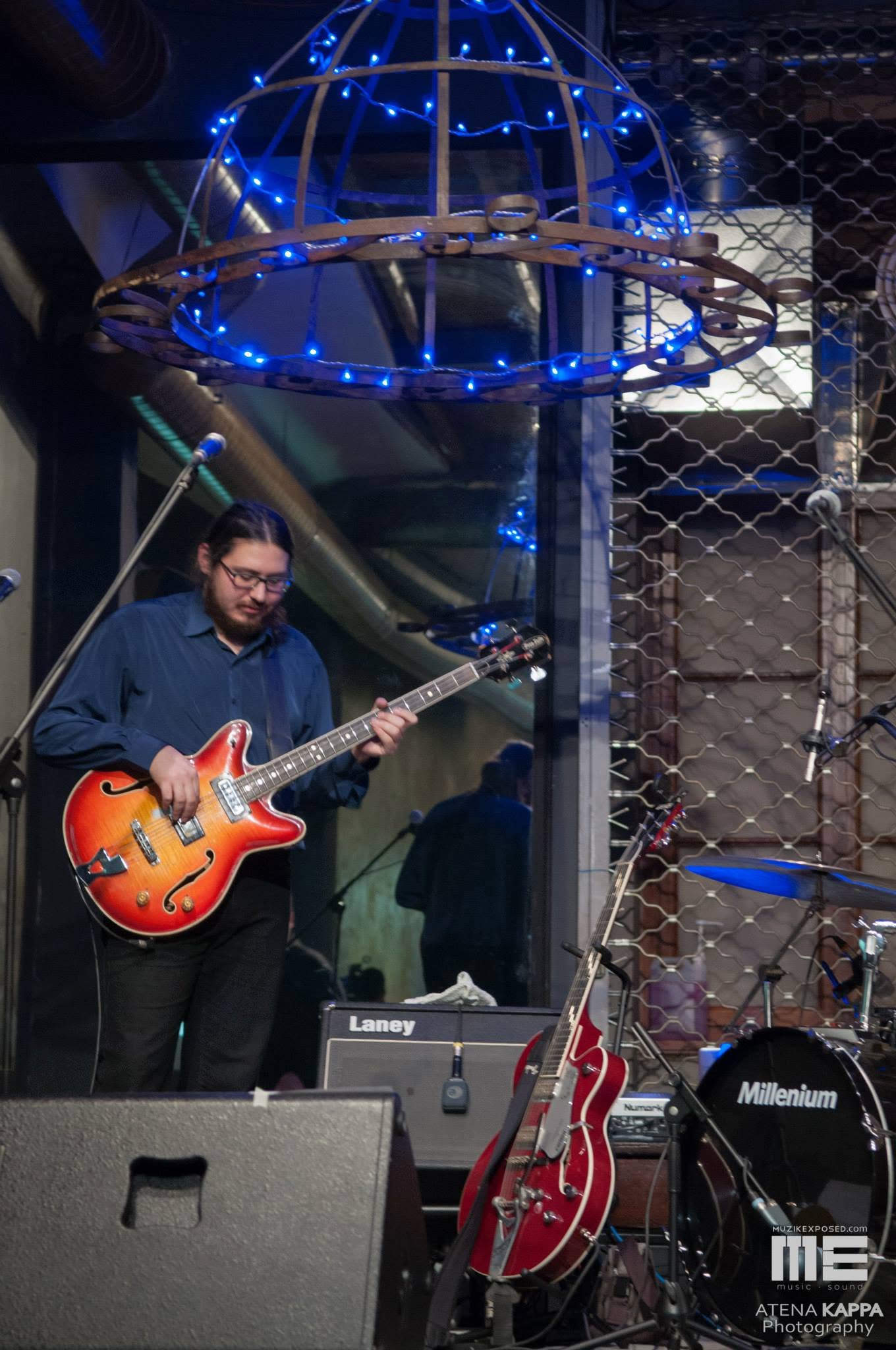 Thanos playing bass with headphones during a rehearsal in 2014
