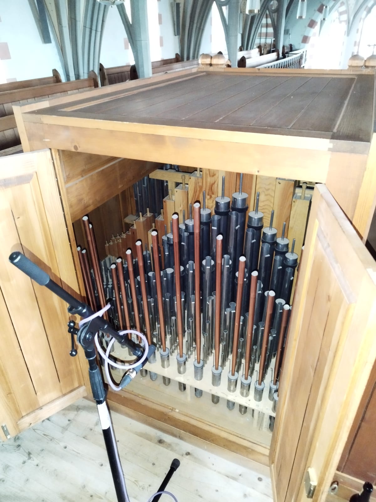 Microphones positioned among organ pipes for a recording in 2024